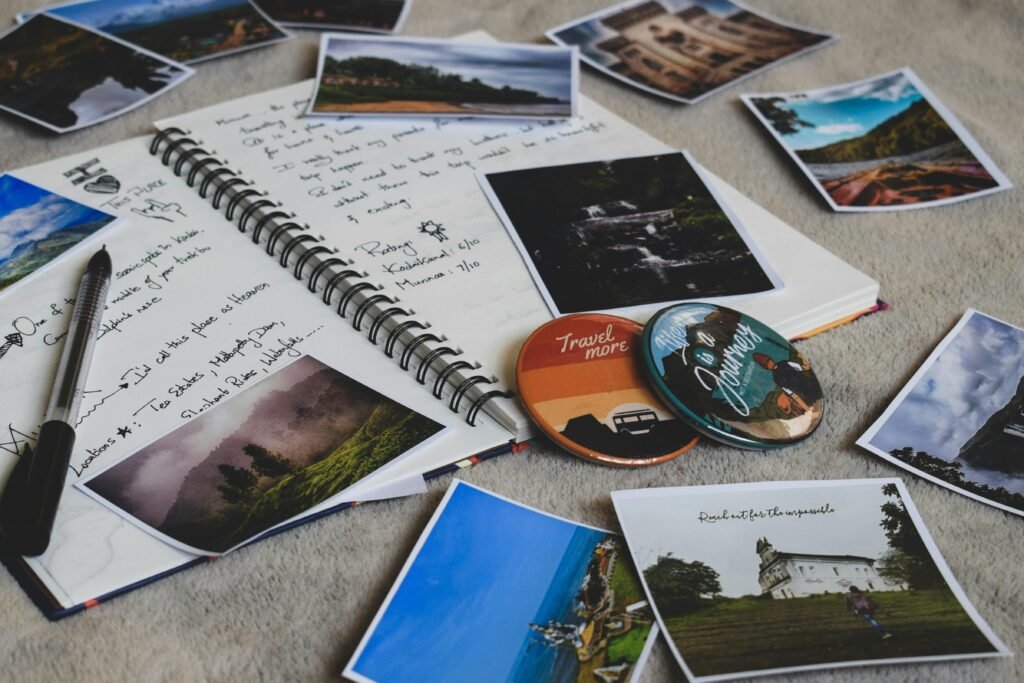 Travel notebook, printed photos and a camera on a wooden table