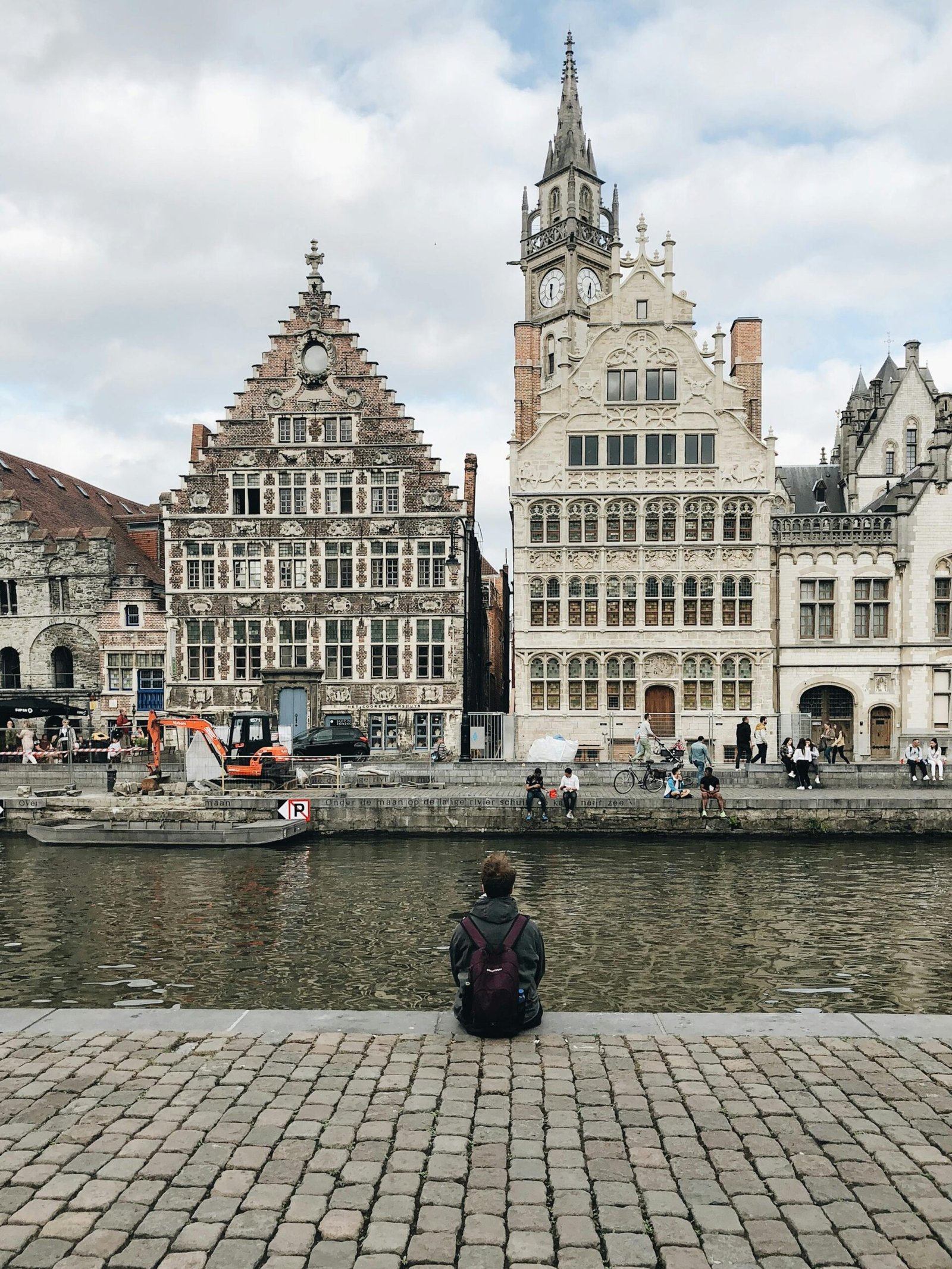 Traveller by a canal lined with historic gabled houses