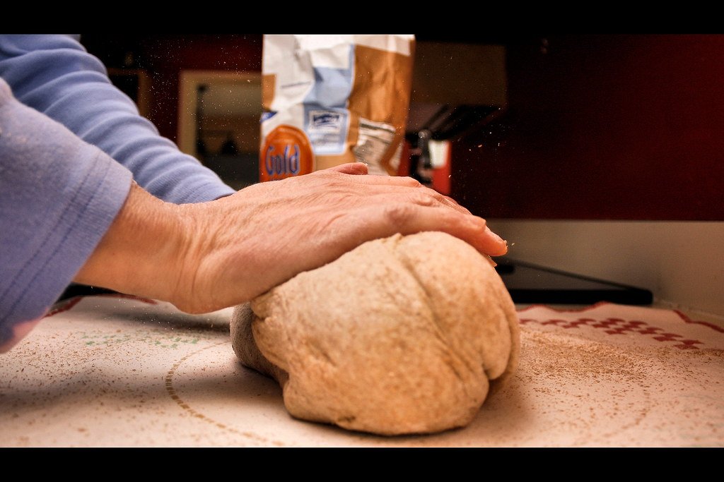 Manos amasando sobre una mesa enharinada