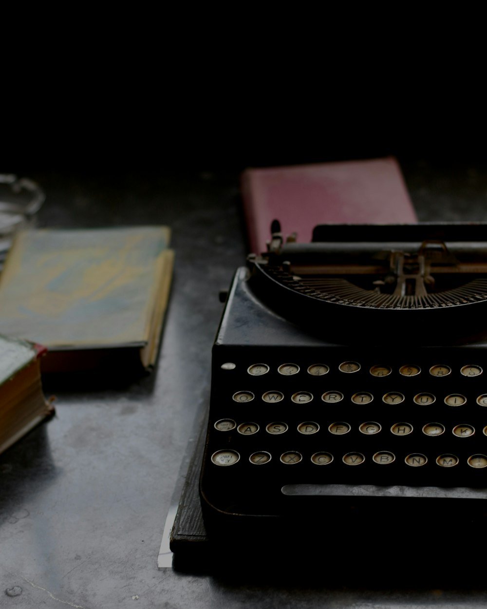 Máquina de escribir antigua junto a libros