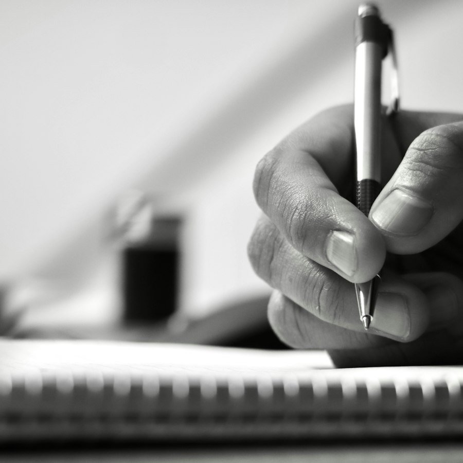 Mano escribiendo en un cuaderno de notas