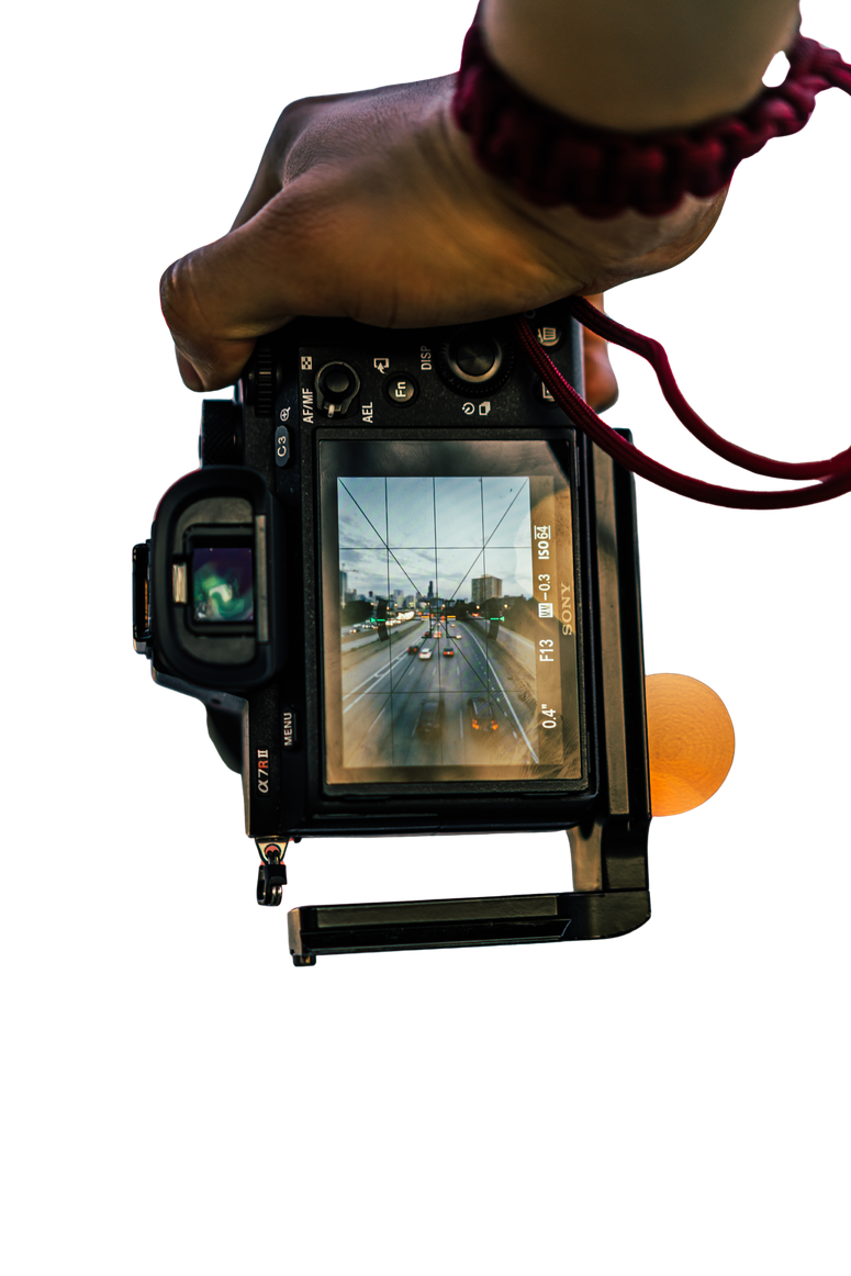 Photographer holding a camera with the screen showing a street scene